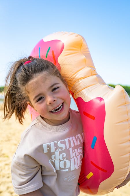 Foto van een meisje met een roze donut opblaasband