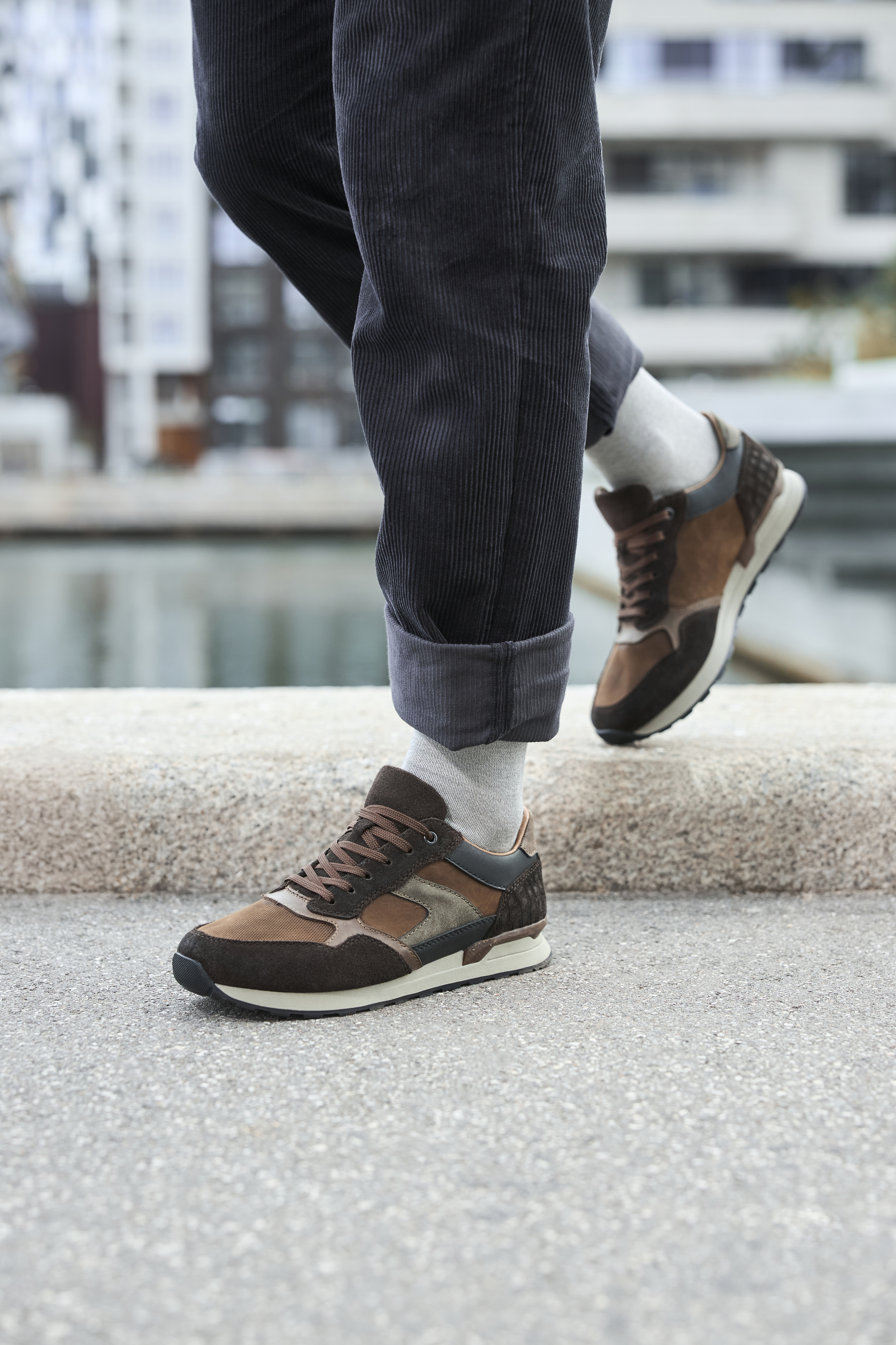 Casual bruine suède heren sneakers met veter en sportieve zool, gedragen op straat met opgerolde broekspijpen.