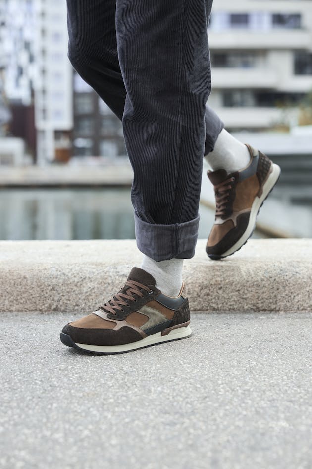 Casual bruine suède heren sneakers met veter en sportieve zool, gedragen op straat met opgerolde broekspijpen.